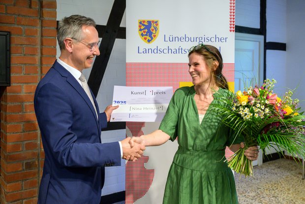 Nina Heinzel erhält die Auszeichnung von Jens Grote, Vorstandsmitglied des Lüneburgischen Landschaftsverbandes und Landrat des Landkreises Heidekreis © Hans-Jürgen Wege. 