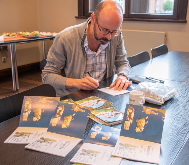 Der Autor und Illustrator Alexander Steffensmeier signiert plattdeutsche Exemplare seines Kinderbuches „Lieselotte luurt“. Der Autor und Illustrator Alexander Steffensmeier signiert plattdeutsche Exemplare seines Kinderbuches „Lieselotte luurt“.